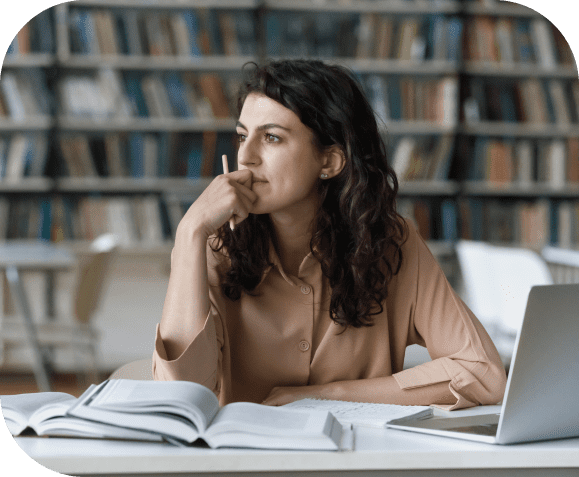 GettyImages-1409086749 Woman thinking in a library setting.